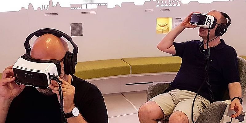 Zwei Männer mit Augmented Reality Brille in einem Touristinfo