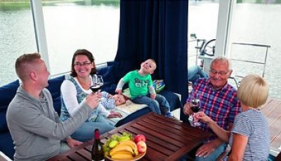Eine Familie mit Großeltern genießt die barrierefreie Bootfahrt