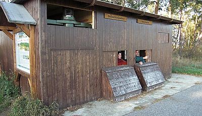 Beobachtungshütte aus dunklem Holz mit zwei Plätzen für Rollstuhlfahrer