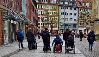 Menschen im Rollstuhl und mit Kinderwagen bewegen sich durch die Innenstadt