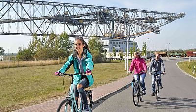 Drei Fahrradfahrer fahren entlang des Besucherbergwerks F60